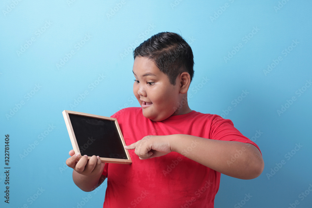 Fat Asian Boy Smiling at Camera and Showing Empty Blackboard Fat Asian Boy Smiling at Camera and Showing Empty Blackboard