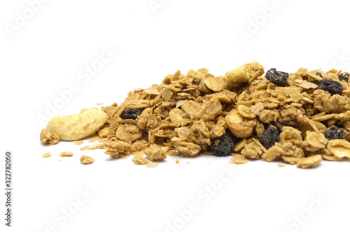Organic homemade crunchy Granola cereal pile on white background. The ingredients mixed with maltflakes, oats, dried raisins and cashew nut.