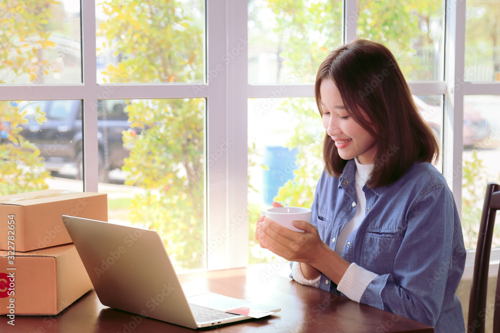Beautiful Asian woman in casual using laptop technology for running small business start up marketing with cardboard box logistic delivery. young entrepreneur using credit card shopping payment, Beautiful Asian woman in casual using laptop technology for running small business start up marketing with cardboard box logistic delivery. young entrepreneur using credit card shopping payment,
