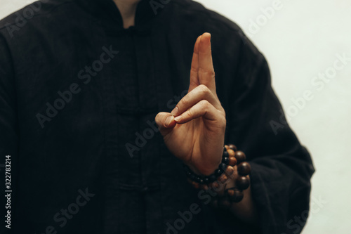 A male yogi sits and shows the mudra of life, and on his hand there is a rosary. Close-up of fingers and the beads on a hand photo
