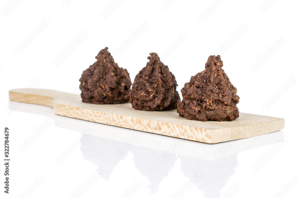 Group of three whole homemade brown coconut cocoa biscuit on small wooden cutting board isolated on white background Group of three whole homemade brown coconut cocoa biscuit on small wooden cutting board isolated on white background