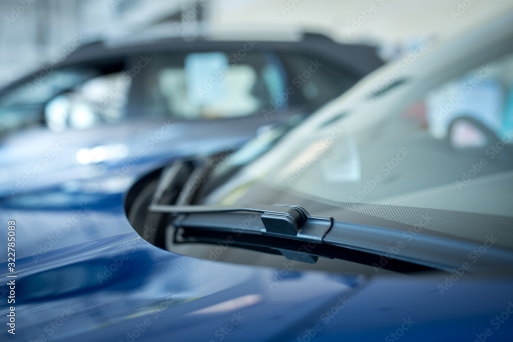 Close up of A windscreen wiper or windshield wiper is a device used to remove rain, snow, ice and debris from a windscreen or windshield. , New cars parked in the showroom Close up of A windscreen wiper or windshield wiper is a device used to remove rain, snow, ice and debris from a windscreen or windshield. , New cars parked in the showroom