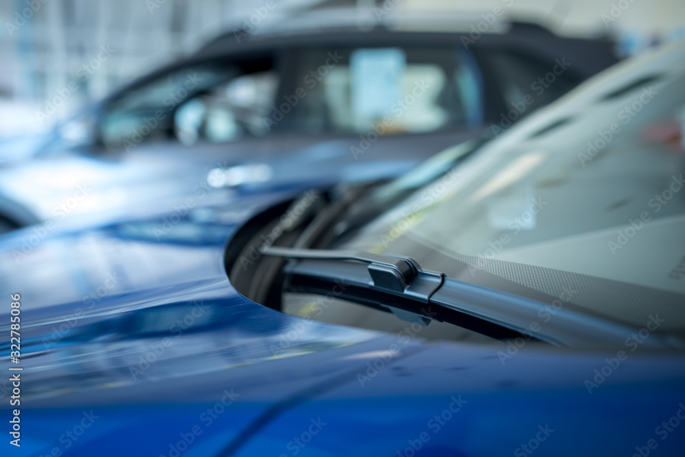 Close up of A windscreen wiper or windshield wiper is a device used to remove rain, snow, ice and debris from a windscreen or windshield. , New cars parked in the showroom Close up of A windscreen wiper or windshield wiper is a device used to remove rain, snow, ice and debris from a windscreen or windshield. , New cars parked in the showroom