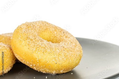 Group of two whole sweet golden mini cinnamon donut on gray ceramic plate isolated on white background