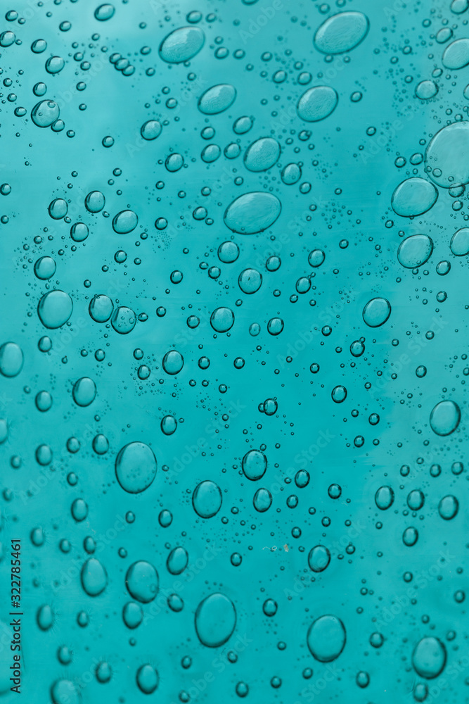 The texture of blue glass with air bubbles inside. A close-up.