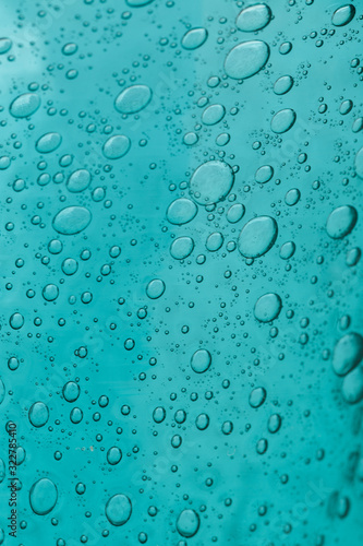 The texture of blue glass with air bubbles inside. A close-up.