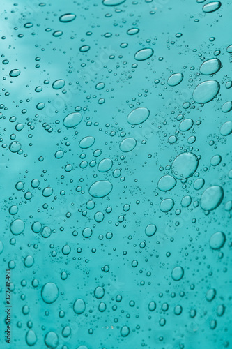 The texture of blue glass with air bubbles inside. A close-up.