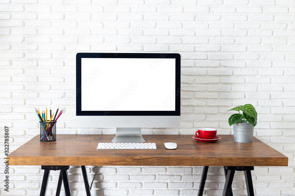 Obraz premium Mockup blank screen computer on a wooden desk. desktop empty white screen, with workspace and office supplies on table