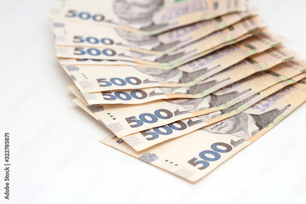 A lot of new banknotes in denominations of 500 Ukrainian hryvnias isolated on a white background with shadow. European money exchange. Ukraine currency. Selective focus A lot of new banknotes in denominations of 500 Ukrainian hryvnias isolated on a white background with shadow. European money exchange. Ukraine currency. Selective focus