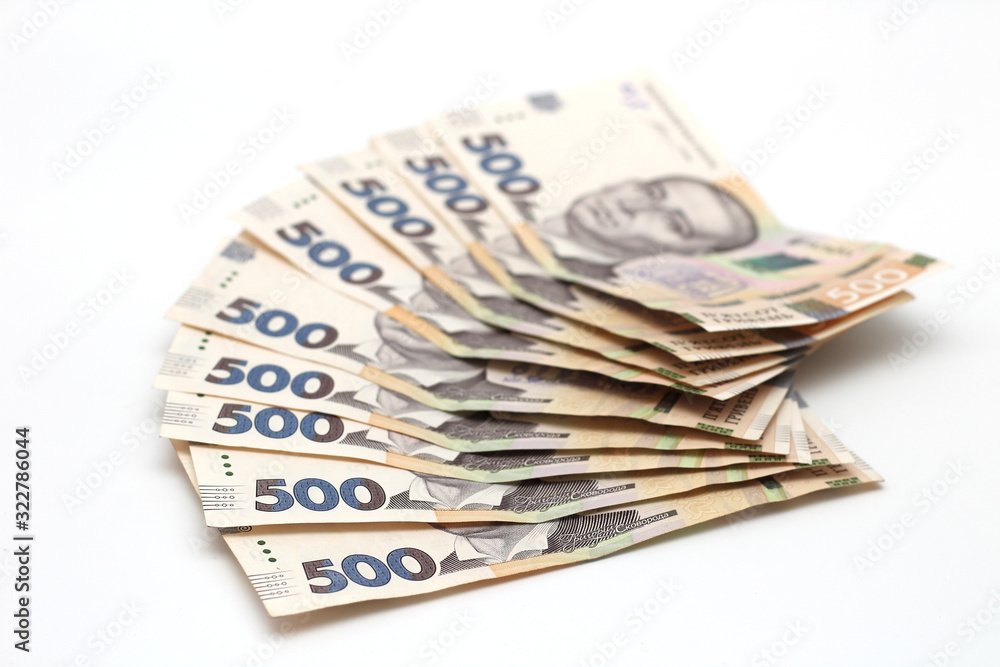 A lot of new banknotes in denominations of 500 Ukrainian hryvnias isolated on a white background with shadow. European money exchange. Ukraine currency. Selective focus A lot of new banknotes in denominations of 500 Ukrainian hryvnias isolated on a white background with shadow. European money exchange. Ukraine currency. Selective focus