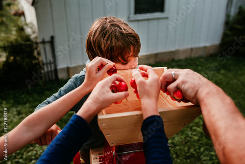 Father and three children in the garden pressing apples to make cider, USA photo