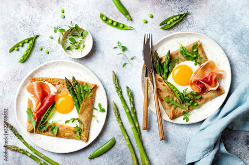 Buckwheat crepes, galette bretonne with asparagus, egg, green pea, jambon or prosciutto. Galette sarrasin, french brittany cuisine photo