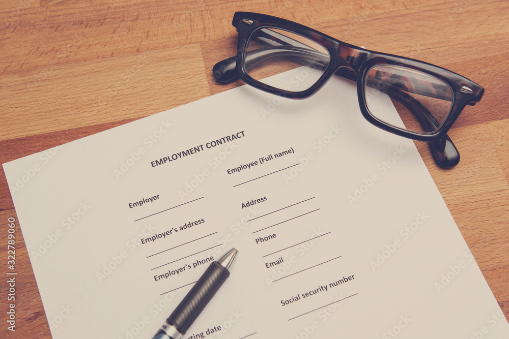 Fototapeta premium Signing an employment contract concept image. White paper with pen. Image has a vintage effect applied.