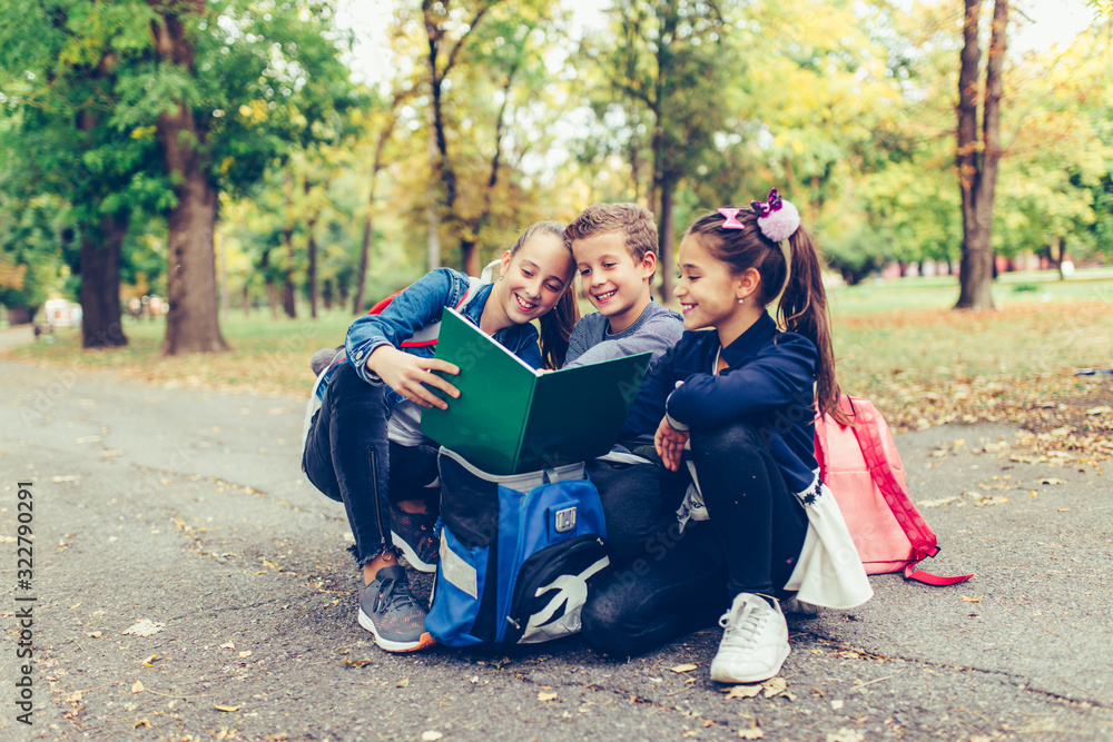Group of school kids with backpacks are having fun, talking, reading a book. Group of school kids with backpacks are having fun, talking, reading a book.
