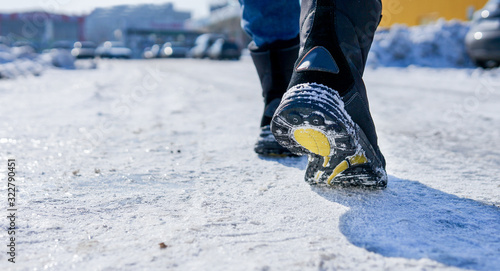 male or female winter boots walking on snowy sleet road photo