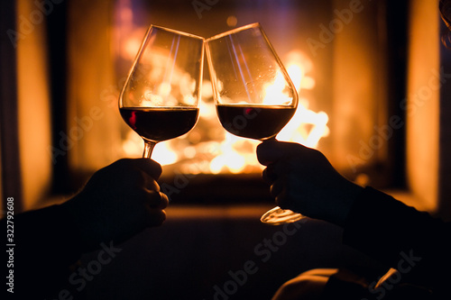 Young couple have romantic dinner with wine over fireplace background