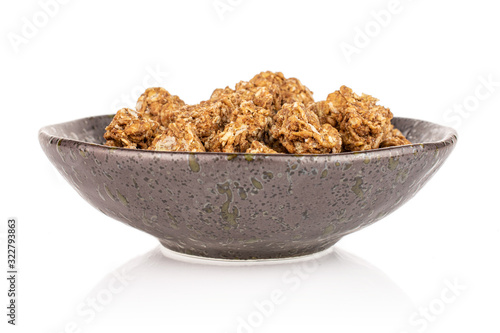 Lot of whole healthy brown cereal heart with cocoa in dark ceramic bowl isolated on white background