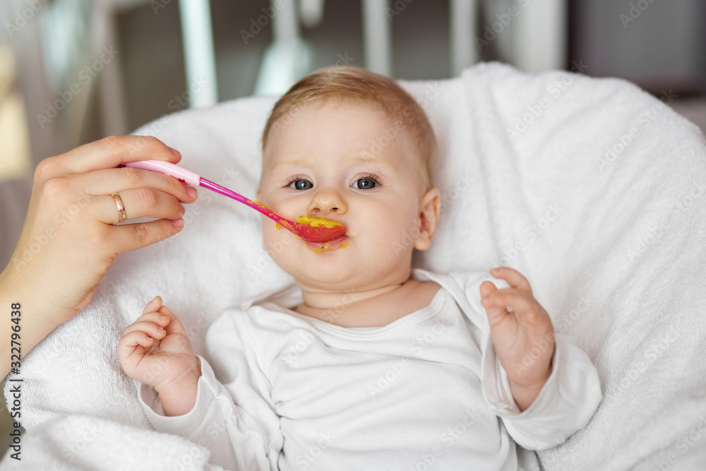 Mom feeds the baby vegetable puree. The concept of childhood, care and baby food. Mom feeds the baby vegetable puree. The concept of childhood, care and baby food.