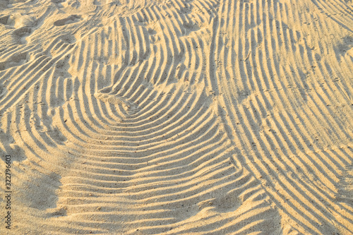 Wave patterns in the sand on the beach under the sun