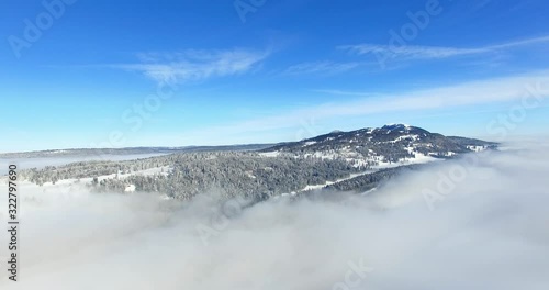 Wallpaper Mural Slow moving aerial shot over clouds of a snowy mountain and forest Torontodigital.ca