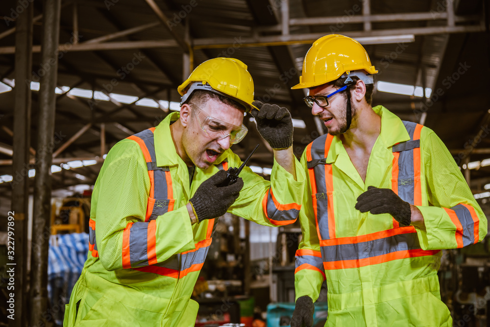 A Engineer industry wearing safety uniform ,black gloves used radio communication for common and discussion work in factory industry A Engineer industry wearing safety uniform ,black gloves used radio communication for common and discussion work in factory industry