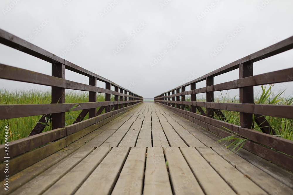 background with wooden bridge with fence and cloudy sky