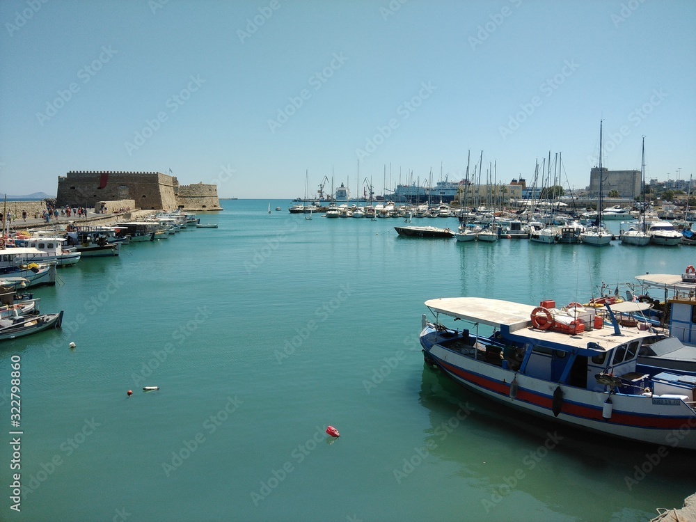Heraklion Harbour, Crete on a sunny day with boats moored in foreground