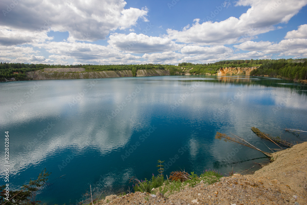 Fototapeta premium Flooded emerald quarry lake with blue water landscape