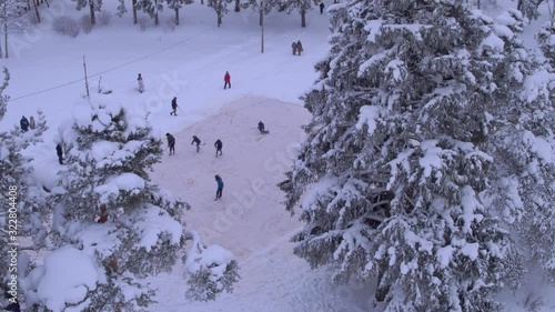 Children play hockey in a snowy forest aerial photography is watched by viewers