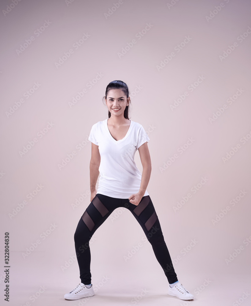 Young lady wearing exercise set outstretch her legs,twist body a little,fists down beside her body,show basic of dance workout,with happy feeling Young lady wearing exercise set outstretch her legs,twist body a little,fists down beside her body,show basic of dance workout,with happy feeling