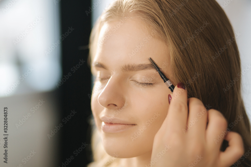 Makeup artist work in her beauty studio. Portrait of Woman applying by professional make up master. Beautiful make up artist start making a makeup for blond hair model Makeup artist work in her beauty studio. Portrait of Woman applying by professional make up master. Beautiful make up artist start making a makeup for blond hair model