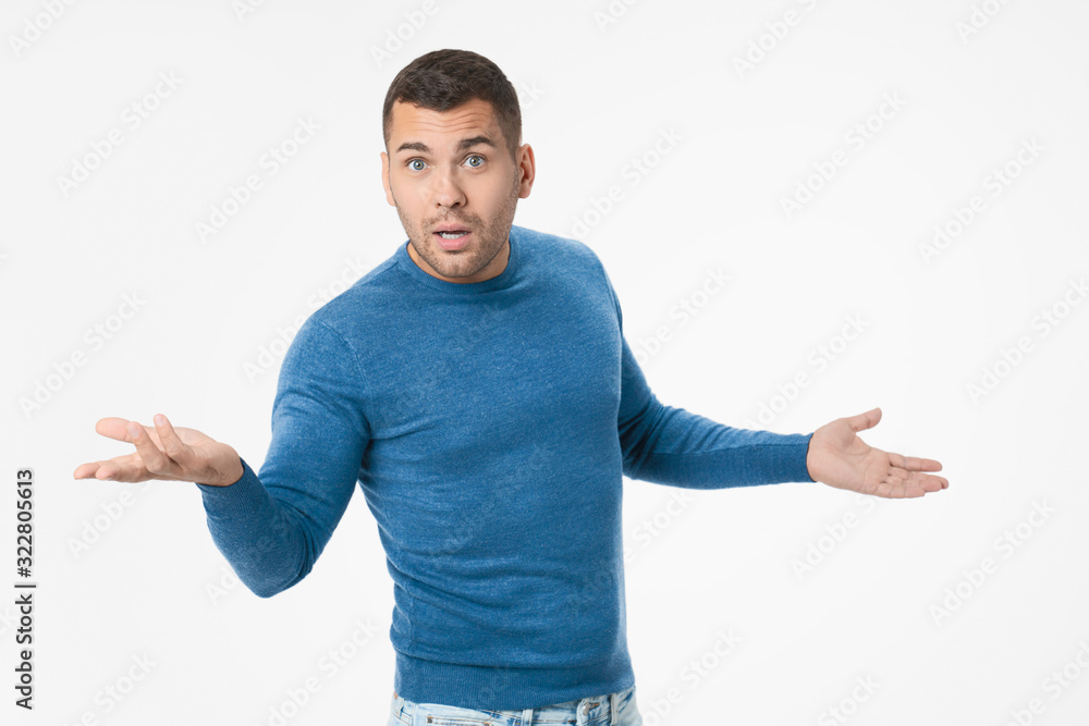 Portrait of unhappy young man with arms out asking what's the problem Portrait of unhappy young man with arms out asking what's the problem