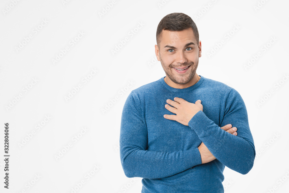 Thankful young man pressing palm to chest against white background