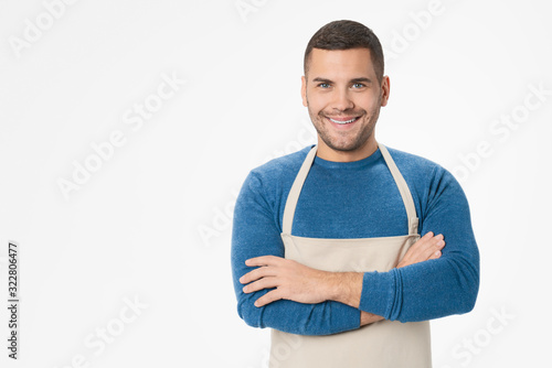 Young handsome shopkeeper man wearing apron standing over isolated white background photo