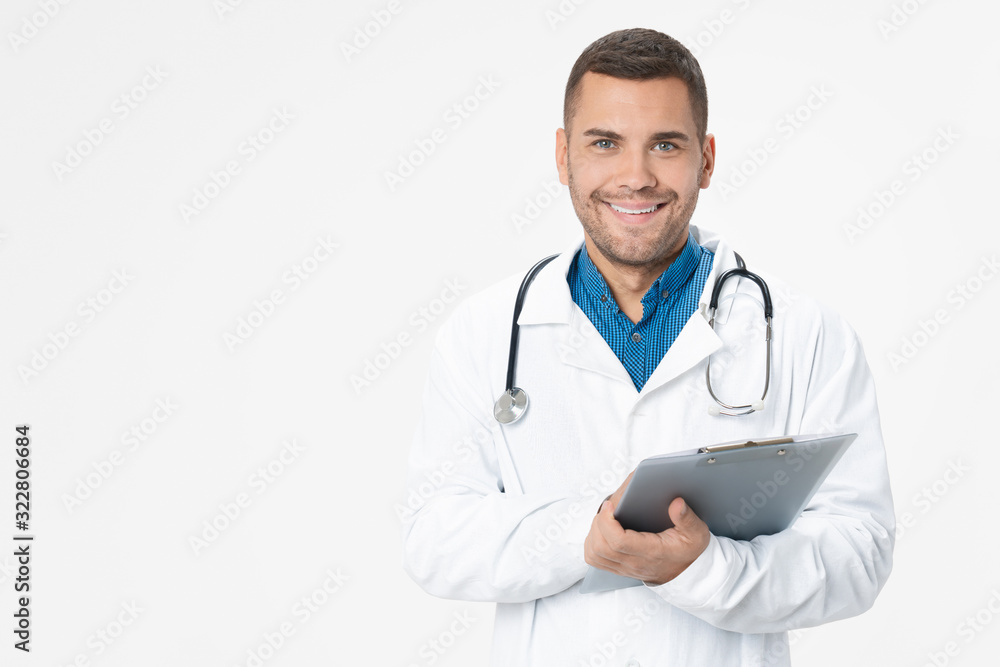 Young doctor smiling with stethoscope and holding clipboard on white color background Young doctor smiling with stethoscope and holding clipboard on white color background