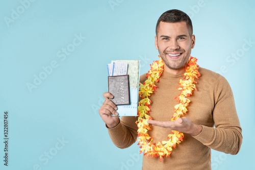 Canvastavla Young smiling man showing on passport with tickets posing isolated on blue wall