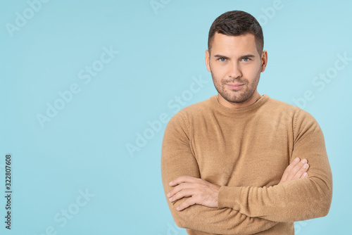 Confident man with crossed arms over blue background