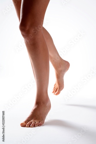 Bare legs shot from the thigh down, in a running style position, shot on white