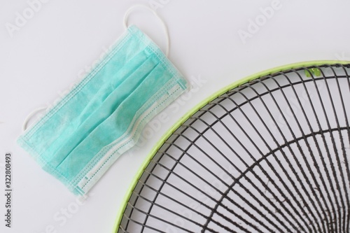 Put on mask before clean the dirty grill of electric fan, air pollution and health care concept.