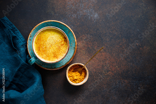 Papier peint Top down view of turmeric latte cup on a textured dark background