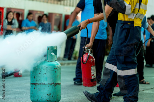 Obraz na plátně Man teaches how to use fire extinguisher to extinguish fire.