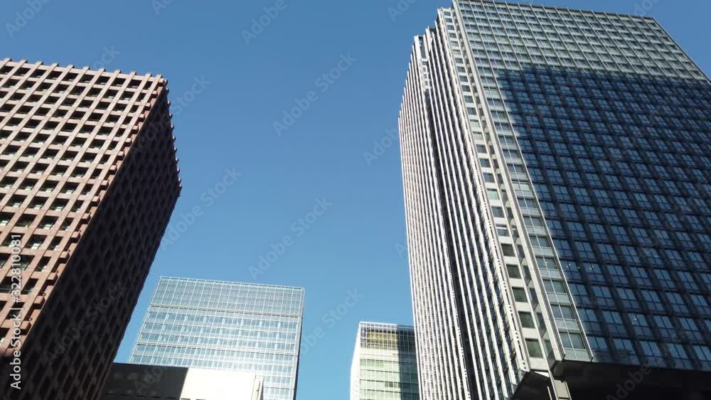 Looking up to high-rise buildings, skyscrapers, architectures in smart city for technology background in Tokyo City with blue sky in Japan Looking up to high-rise buildings, skyscrapers, architectures in smart city for technology background in Tokyo City with blue sky in Japan