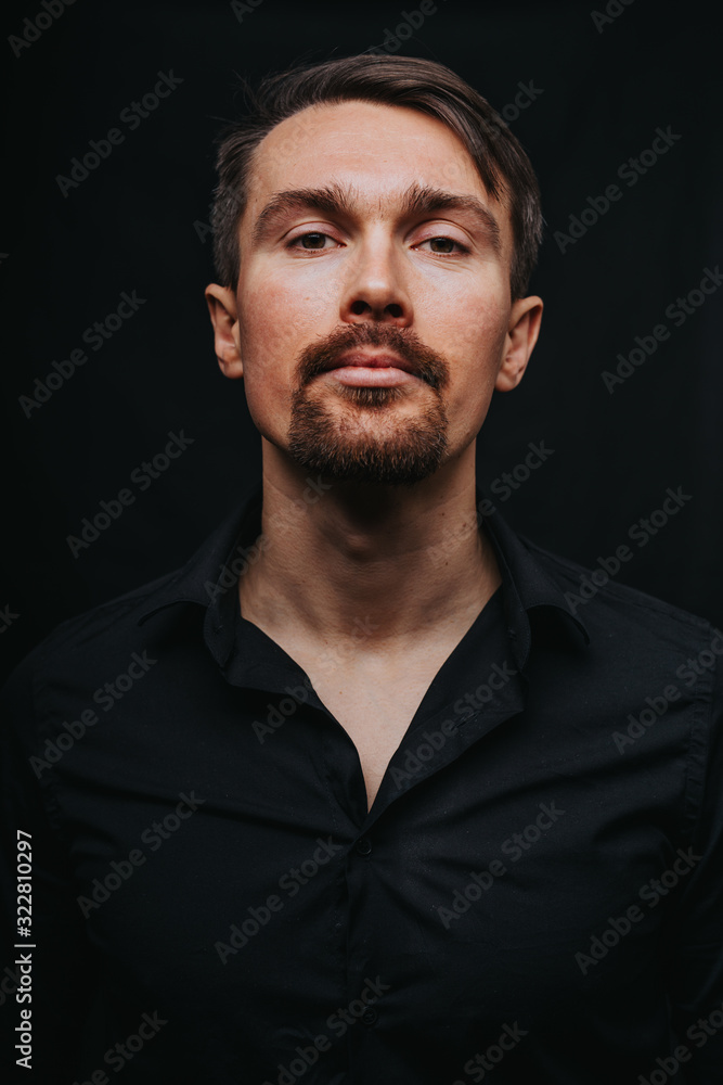 Handsome man. Photo in a photo studio on a black background. A young man expresses his emotions with expressions, gesticulation and attitude. Handsome man. Photo in a photo studio on a black background. A young man expresses his emotions with expressions, gesticulation and attitude.