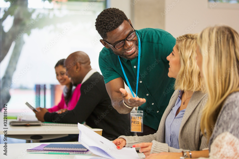 Community college instructor helping students in classroom Community college instructor helping students in classroom