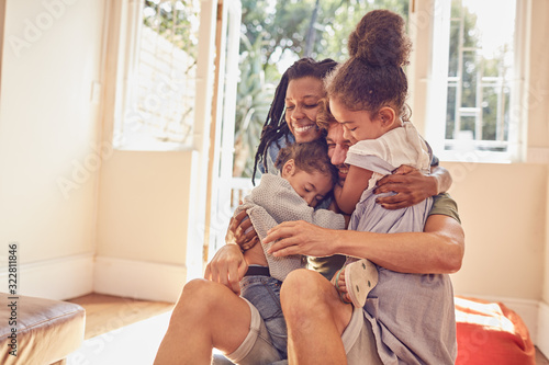 Happy affectionate young family hugging