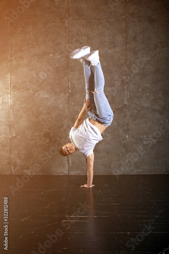 Fototapeta Naklejka Na Ścianę i Meble -  Breakdance action, dancer posing in dance studio