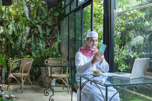 Photography Arab muslim businessmen wear white traditional clothing in hand use smart phone