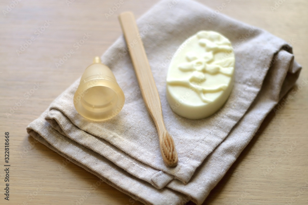 Linen cloth, soap, bamboo toothbrush and menstrual cup. Zero waste bathroom products. Selective focus. Linen cloth, soap, bamboo toothbrush and menstrual cup. Zero waste bathroom products. Selective focus.