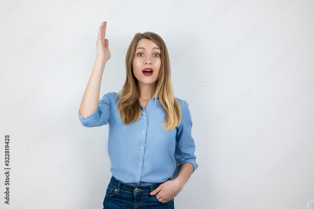 young blond positive woman looks excited raising her hand to ask question standing on isolated white background young blond positive woman looks excited raising her hand to ask question standing on isolated white background