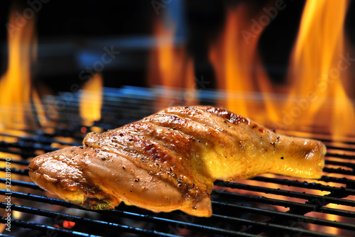 Photography Grill bbq roast chicken thigh on the flaming grill